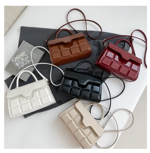 Flat lay view of five checkered texture handbags in white, caramel, red, black, and beige