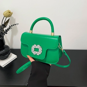 Sac à main vert chic avec boucle en strass et poignée dans un décor minimaliste