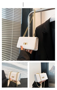 Détail du sac à rabat blanc motif crocodile avec chaîne dorée et fermoir rotatif
