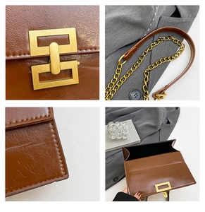 Close-up detail of brown wrinkled leather bag showing golden chain and square metal lock