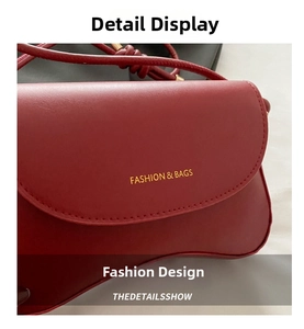 Detail of dark red leather shoulder bag showing the golden logo and smooth flap texture