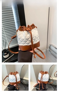 Detail of white quilted bucket bag with brown leather accents and drawstring closure