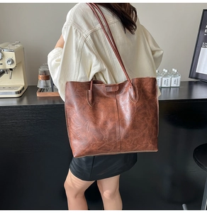 Gros plan d'un grand cabas vintage en cuir marron avec de longues bandoulières souples