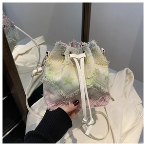 Close-up of rainbow tie-dye bucket bag featuring green star pattern and fringe edges