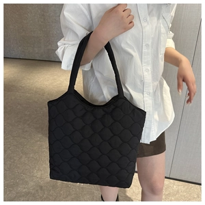 Fashionable black quilted puffer tote bag with wavy stitching for winter casual style