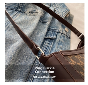 Detail view of silver metal buckle on a dark brown textured crossbody shoulder bag
