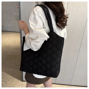 Detail of wave quilted pattern and stitching on black large puffy tote bag