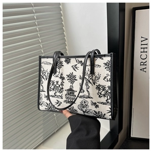 Close-up of landscape embroidery detail on a structured black and white tote bag