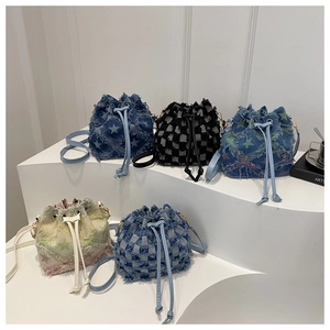 Detail view of denim bucket bags with star patterns and checkered prints on displays