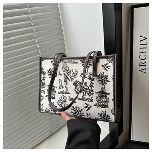 Detail of Chinese style embroidery on canvas tote bag with brown leather trim and handles