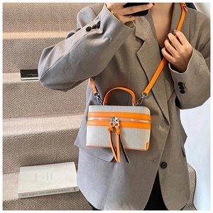 Detail of contrast stitching box bag with long leather tassels and adjustable strap