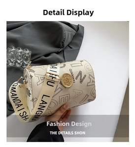 Detail of cream barrel bag featuring large letter patterns and gold metal logo