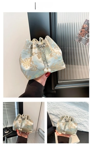 Détail d'un sac seau en soie avec broderies florales, chaîne argentée et perles