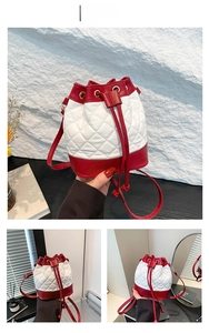Detail of red and white quilted bucket bag with drawstring closure and contrast leather
