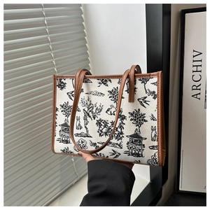 Close-up of vintage canvas tote bag with landscape print and premium brown leather trim