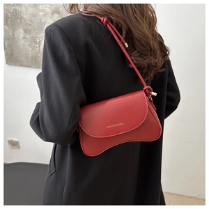 Model wearing a red matte leather shoulder bag with FASHION & BAGS gold lettering