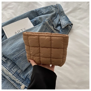Detail view of a brown quilted makeup bag made of soft water-resistant nylon material
