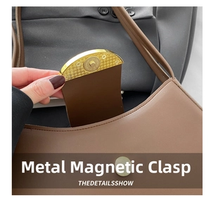 Detail of premium gold magnetic clasp closure on elegant brown leather shoulder bag