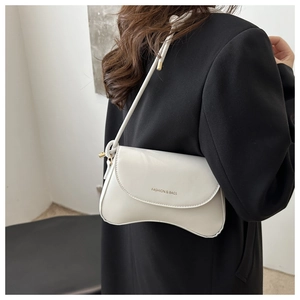 Detail of a creamy white curved crossbody bag with Fashion & Bags text on black blazer