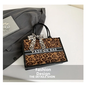 Détail du sac cabas léopard avec ruban mode noir et décoration de poignée en soie