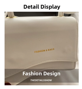 Detail of white leather handbag with golden FASHION & BAGS logo and metal hardware