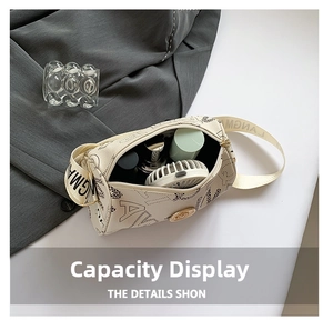 Top view of cream cylindrical crossbody bag showing interior capacity and lettered strap