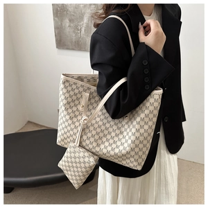 Detail of off-white tote bag set with all-over M pattern and matching mini zipper pouch