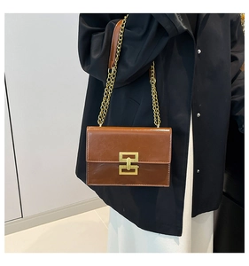 Detailed view of brown oil wax leather shoulder bag featuring a gold geometric metal buckle