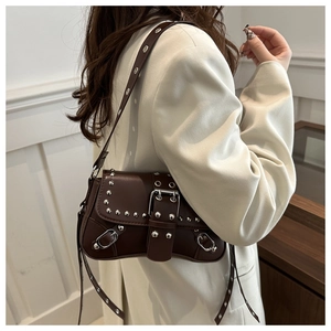 Detail of vintage coffee leather crossbody bag with silver studs and metal buckle closure
