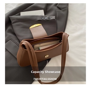 Detailed interior view of a brown leather shoulder bag with a gold buckle and pockets