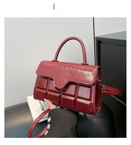 Detail of red embossed square texture on glossy PU leather small crossbody handbag