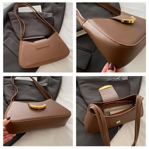 Detail of vintage brown baguette bag featuring gold C-buckle and spacious interior