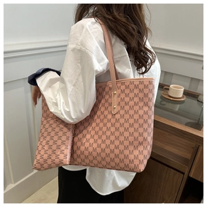 Close-up of pink tote bag with M-pattern print, matching pouch and gold hardware details