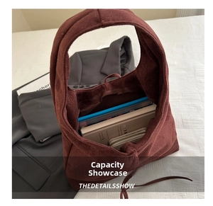 Spacious interior of dark red suede tote bag showing capacity for books and wallets