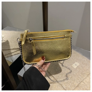 Detail of gold metallic textured crossbody bag with silver bead trim and chain strap