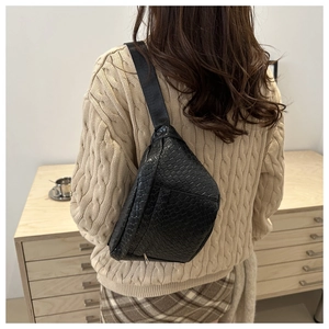 Gros plan sur la texture tressée noire d'un sac de poitrine minimaliste pour hommes