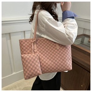 Pink tote bag set with monogram print and matching pouch shown on a shoulder