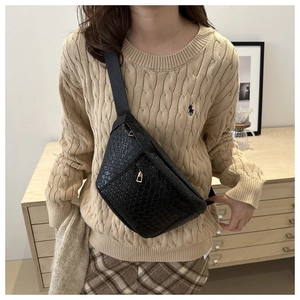 Détail de la texture tissée noire du sac de poitrine tendance avec fermeture éclair