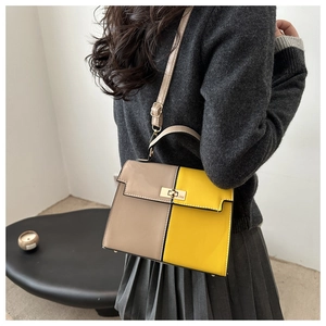 Detail view of khaki and yellow contrast shoulder bag with golden metal rotary lock