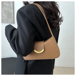 Detailed side view of a dark brown leather underarm bag with a golden crescent buckle