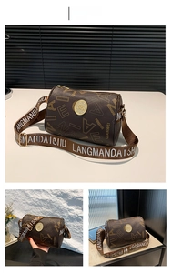Macro detail of dark brown cylindrical Boston bag with embossed logo and monogram strap