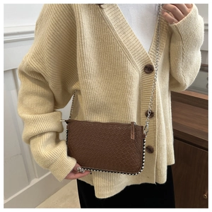 Detail of woven texture brown crossbody bag with silver beads and chain strap