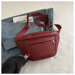 Detail of woven burgundy chest bag showing faux leather texture and adjustable strap