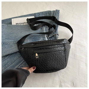 Close-up of black woven leather texture and gold zipper detail on casual chest bag