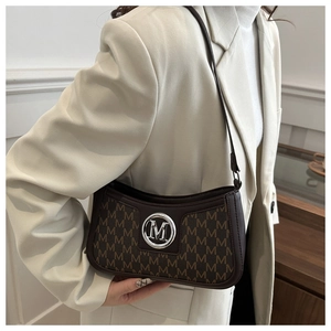 Close-up of vintage monogram fabric and metallic M logo on the brown crescent bag