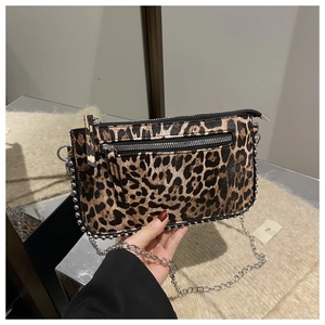 Detail of leopard print underarm bag with silver studs and metal chain strap