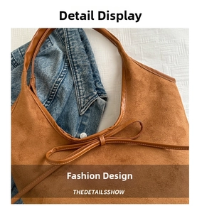 Detail of brown frosted leather tote bag featuring a bow tie and smooth trim edge