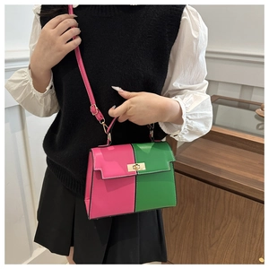 Close-up of pink and green trapezoid Kelly bag with gold twist lock and PU leather texture