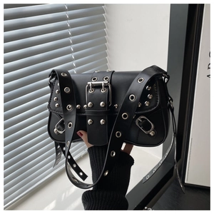 Detail of punk style black PU leather crossbody bag with silver rivets and eyelets