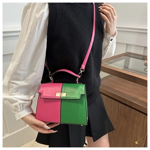 Model wearing a pink and green color-block Kelly bag with a gold twist-lock closure